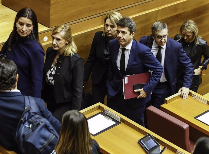 Imagen del presidente de la Generalitat Valenciana, Carlos Mazón (c), a su salida de la comparecencia en el pleno de Les Corts para explicar la gestión de la DANA. 