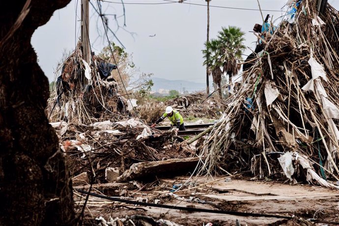 Un hombre participa en la recogida de escombros en una zona afectada por la DANA