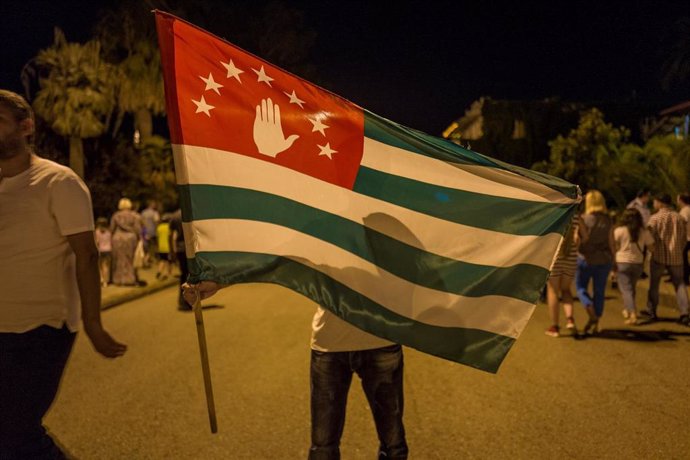 Archivo - Un manifestante con la bandera de Abjasia 