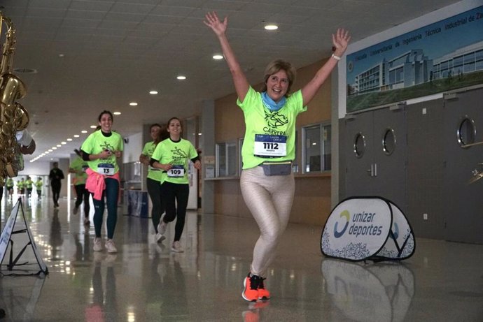 Una de las participantes celebra con los brazos en alto al paso por el interior del edificio univeristario.