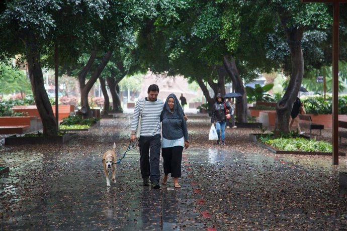 Archivo - Una pareja camina bajo la lluvia, a 25 de septiembre de 2022, en Las Palmas de Gran Canaria, Canarias (España). El Gobierno de Canarias ha pedido evitar desplazamientos durante este fin de semana por la previsión de lluvias, viento y tormentas p