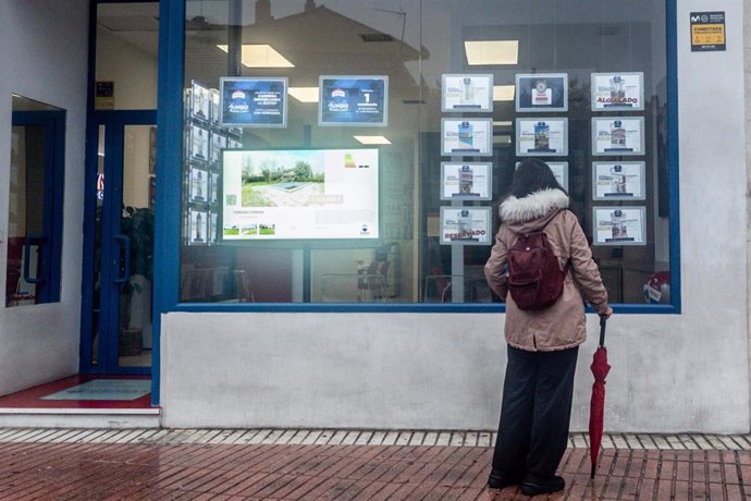 Archivo - Una mujer observa las ofertas de una inmobiliaria, a 16 de octubre de 2024, en Madrid (España).