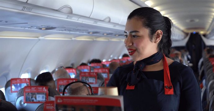 Una tripulante de cabina de Iberia Express ofreciendo el servicio a bordo.