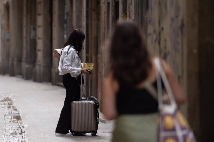 Archivo - Dos turistas con maletas en el centro de Barcelona