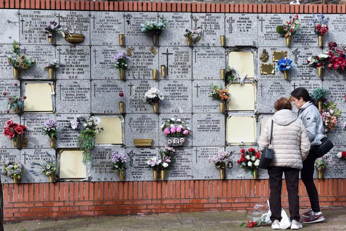 Varias personas llevan flores a un ser querido, en el Cementerio de la Almudena, a 1 de noviembre de 2024, en Madrid (España).