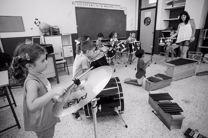 Niños dando clases de música.