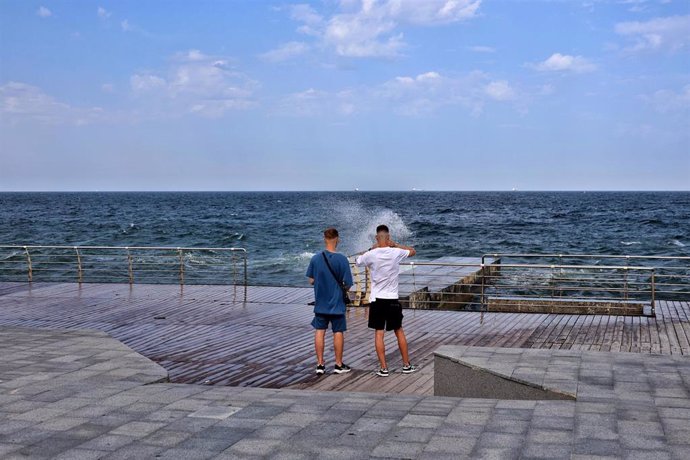 Archivo - Dos hombres frente a la costa del mar Negro, en Odesa