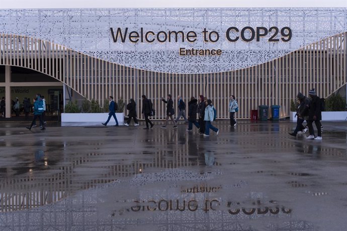 HANDOUT - 14 November 2024, Azerbaijan, Baku: Participants walk in front of a main entrance during the United Nations Climate Change Conference COP29 Photo: -/COP29/dpa - ATTENTION: editorial use only and only if the credit mentioned above is referenced i