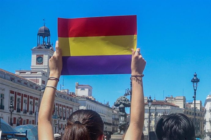 Archivo - Una persona sujeta una bandera republicana en la Puerta del Sol