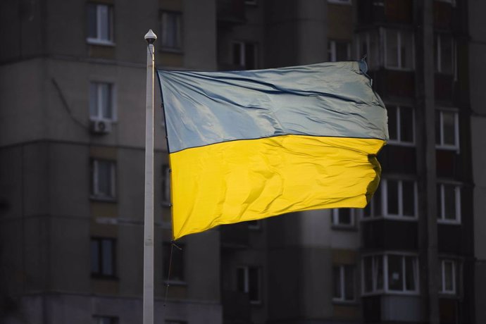 November 20, 2024, Kyiv, Kyiv City, Ukraine: Ukrainian flag seen in Kyiv in front of residential high-rise building. Whilst the Ukrainian flag is light by sunlight, many apartments remain dark due to power cuts introduced after Russia attacked critical in