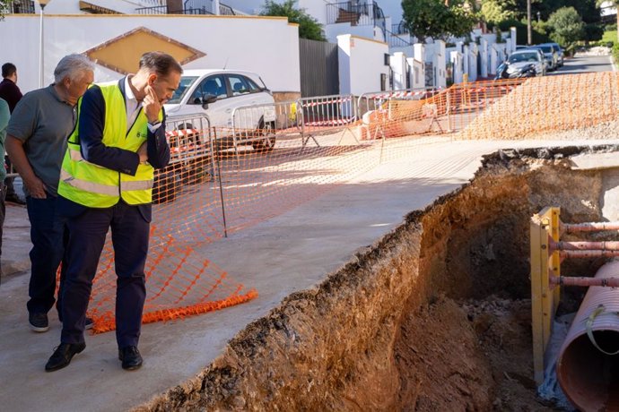 El alcalde de Benalmádena (Málaga), Juan Antonio Lara, acompañado del edil de Servicios Operativos, Juan Olea, visita los trabajos que se están realizando para reparar el socavón provocado la pasada semana por la DANA