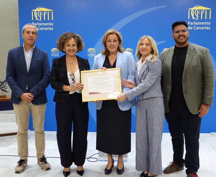 La presidenta del Parlamento de Canarias, Astrid Pérez (c), con el reconocimiento como embajadora de los 'Premios Más Mujer Canarias 2025'