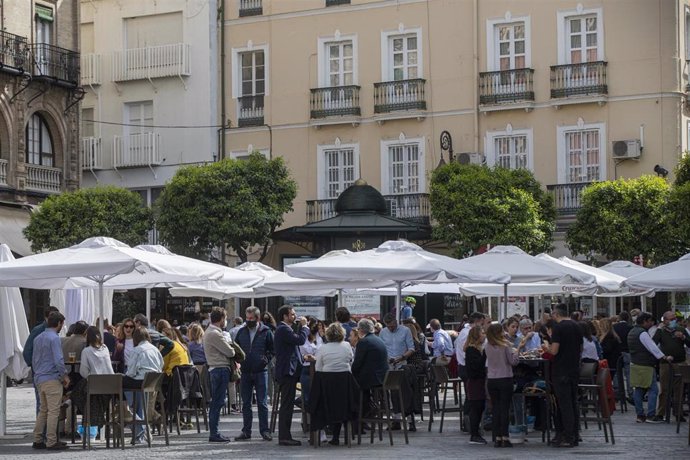 Archivo - Imagen de archivo de personas en la terraza de un bar en Sevilla.