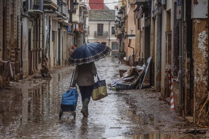 Una personas con un paraguas, a 13 de noviembre de 2024, en Paiporta, Valencia