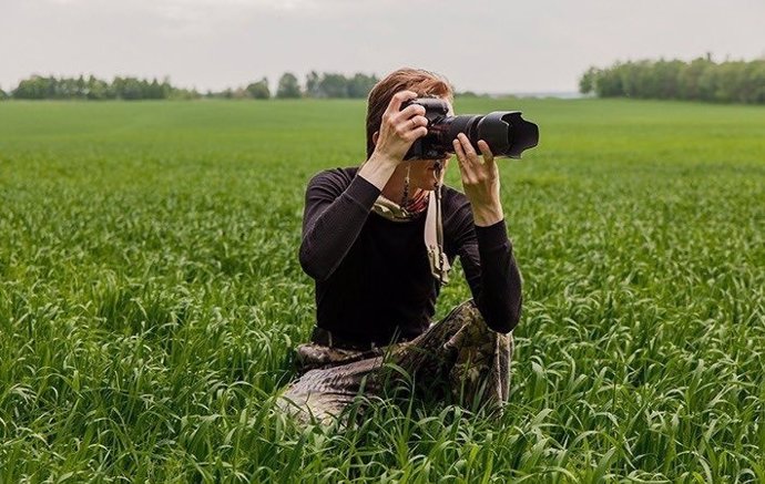 Archivo - Una mujer realizando una fotografía en el campo. 