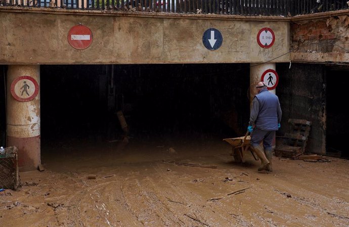 Un hombre limpia un garaje en Catarroja.