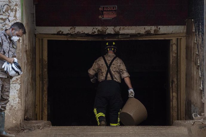 Un hombre trabaja para limpiar un garaje tras la dana.