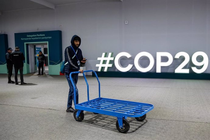 Un trabajador de la COP29 empuja un carro en la ceremonia de clausura de las negociaciones 