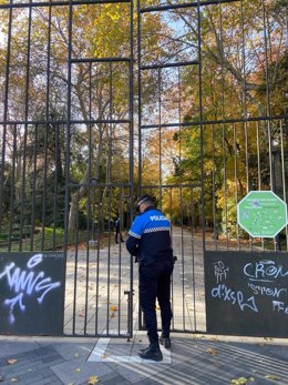 Un agente de la Policía Municipal de Valladolid cierra el Campo Grande ante el aviso amarillo por vientos.