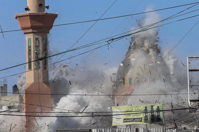 November 23, 2024, Nusairat, Gaza Strip, Palestinian Territory: Palestinians watch smoke rising during an Israeli airstrike on the Al Farouq Mosque in the Al Nuseirat refugee camp, central Gaza Strip.