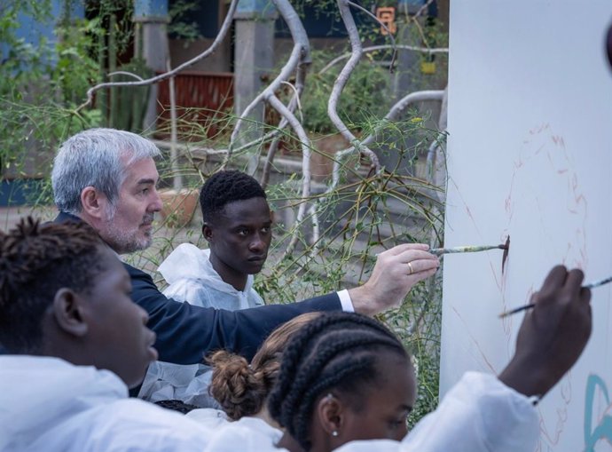 El presidente de Canarias, Fernando Clavijo, pintando un mural con jóvenes migrantes antes de participar en un seminario sobre migración en Casa África, en Las Palmas de Gran Canaria