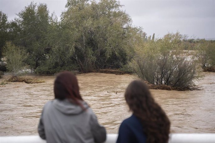 Varias personas observan la crecida del río Magre, a 29 de octubre de 2024, en Alfarp