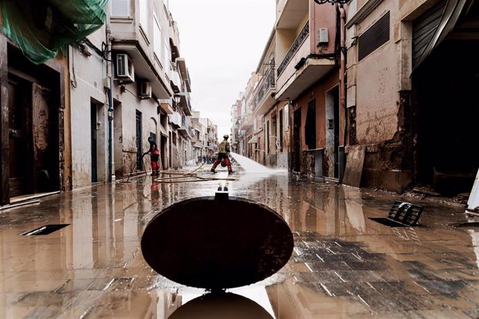 Un bombero limpia una calle en una zona afectada por la DANA. 