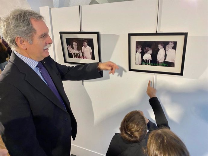 Viso contempla, junto a algunos escolares, las fotografías de la exposición.