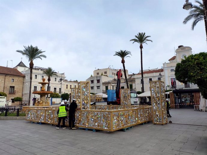 Operarios instalan la decoración navideña en la Plaza de España de Mérida