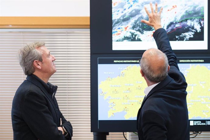 El presidente de la Xunta de Galicia, Alfonso Rueda, y Juan Taboada, de MeteoGalicia, en la sede de la entidad, en Santiago