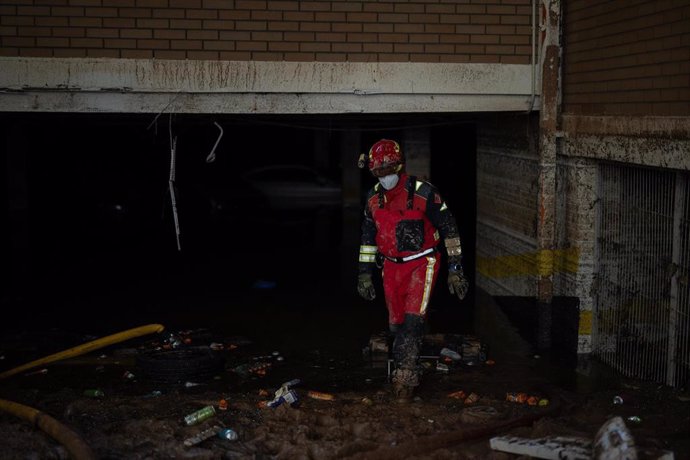 Un bombero revisa un garaje inundado por la dana en Benetússer.