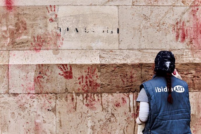 Una operaria limpia pintadas de la fachada del Palau de la Generalitat.