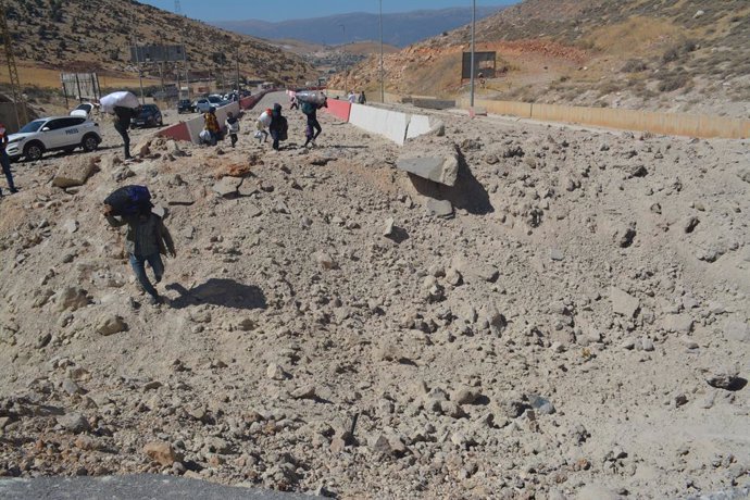 Archivo - BEIRUT, Oct. 5, 2024  -- Displaced people from Lebanon cross a destroyed road caused by an Israeli airstrike near the Masnaa Border Crossing, Lebanon, Oct. 4, 2024.   The Syrian Foreign Ministry denounced an Israeli airstrike on the Syria-Lebano