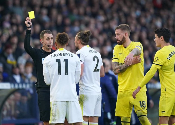 Archivo - El colegiado inglés David Coote amonesta con una tarjeta amarilla a un futbolista del Leeds United. 