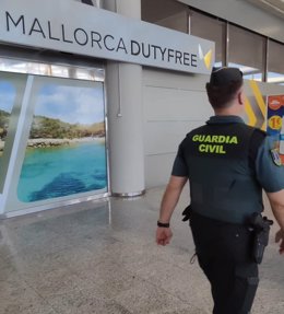 Un agente de la Guardia Civil, frente al Duty Free del aeropuerto de Palma.