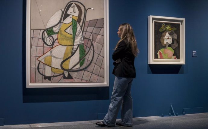 Una visitante observando dos pinturas de la exposición Arte y naturaleza. Un siglo de biomorfismo.