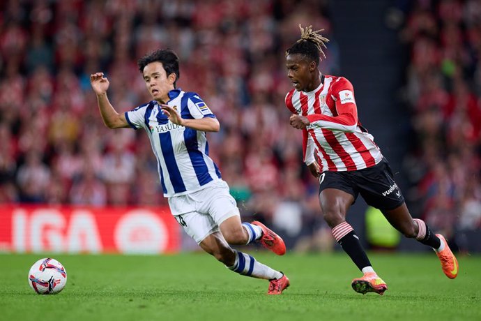 Takefusa Kubo of Real Sociedad competes for the ball with Nico Williams of Athletic Club during the LaLiga EA Sports match between Athletic Club and Real Sociedad at San Mames on November 24, 2024, in Bilbao, Spain.