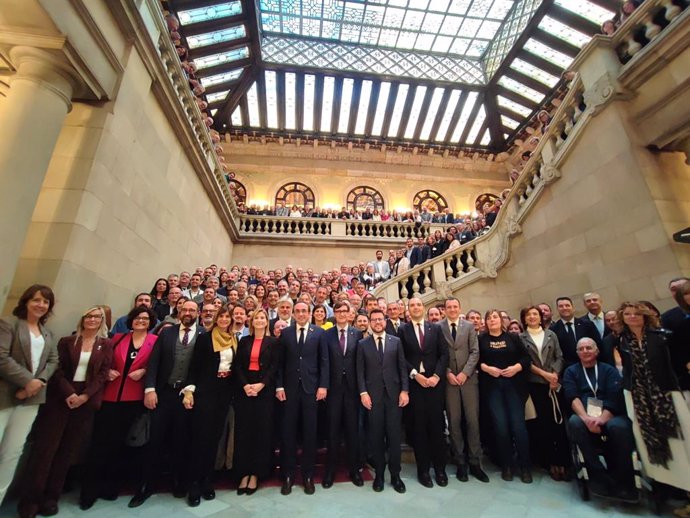 El president de la Generalitat, Salvador Illa; el president del Parlament, Josep Rull; els consellers Albert Dalmau i Òscar Ordeig, i l'expresident Pere Aragonès i altres representants amb les entitats municipalistes al Parlament