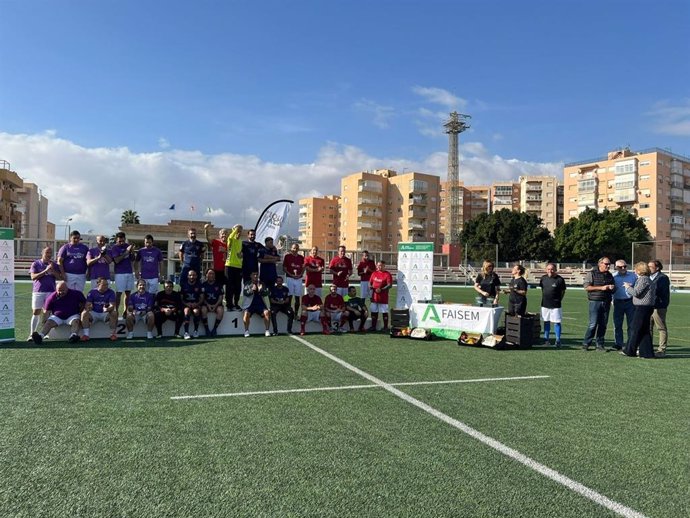 Los participantes de la novena edición del evento 'Tiqui Taca por la Salud Mental' posan junto a sus trofeos en el campo de fútbol.