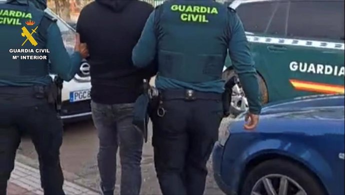 Un detenido custodiado por un agente de la Guardia Civil.