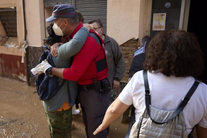 Un policía foral abraza a una vecina de Paiporta durante las labores de cooperación tras el desastre de la DANA.