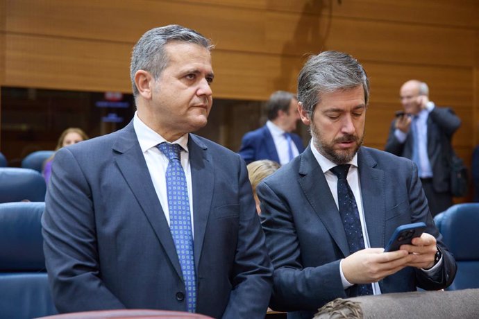 El consejero de Vivienda, Transportes e infraestructuras, Jorge Rodrigo (i), y el consejero de Presidencia, Justicia y Administración Local, Miguel Ángel García (d), durante un pleno en la Asamblea de Madrid, a 14 de noviembre de 2024, en Madrid (España).