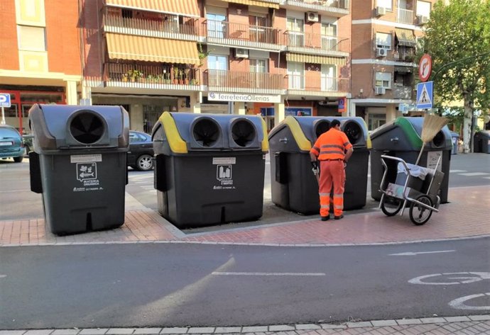 Archivo - Un trabajador de Sadeco junto a unos contenedores.