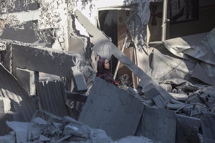 Una mujer comprueba los restos de un edificio destruido por un bombardeo perpetrado por el Ejército de Israel contra el campamento de refugiados de Nuseirat, en la Franja de Gaza (archivo)