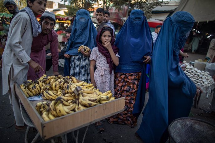 Archivo - FILED - 17 September 2021, Afghanistan, Kunduz: Afghani women shop in a market in Kunduz, northern Afghanistan. Photo: Oliver Weiken/dpa