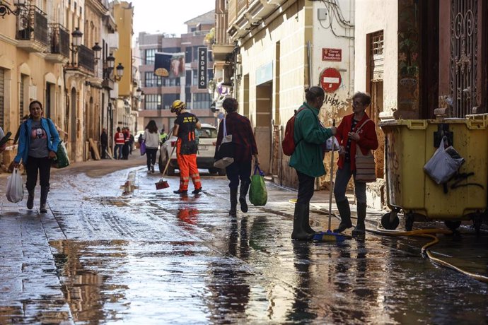 Varias personas en una calle cubierta de barro, a 28 de noviembre de 2024, en Paiporta, Valencia (Comunidad Valenciana). 