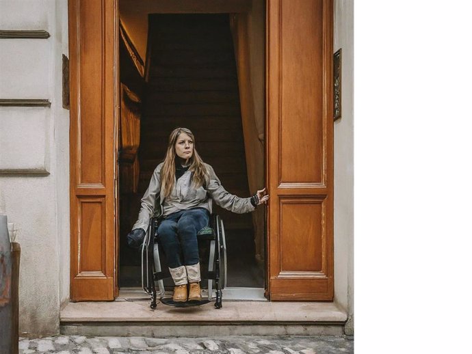 Mujer con discapacidad en un edficio no adaptado.