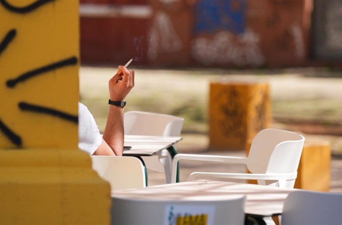 Archivo - Una persona fumando en una terraza. A 12 de marzo de 2024, en Sevilla (Andalucía, España). 