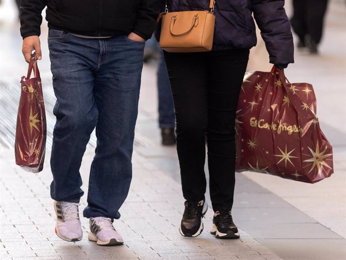 Archivo - Dos personas llevan bolsas con regalos para Reyes, a 5 de enero de 2024, en Madrid (España).