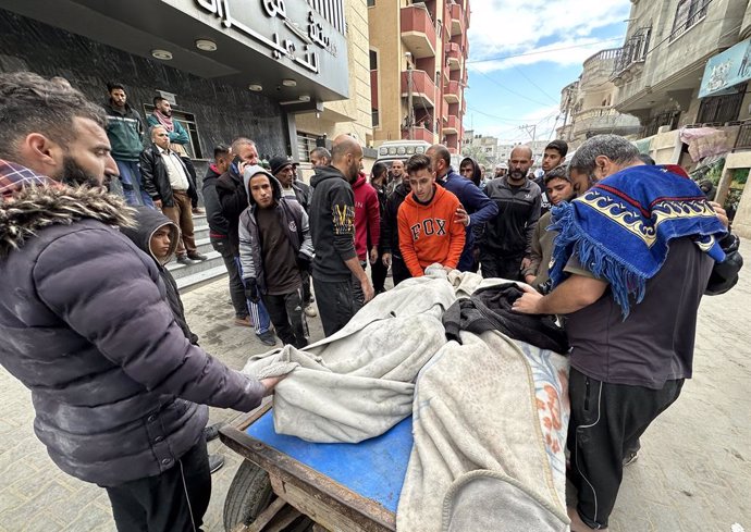 Un grupo de palestinos junto a los cuerpos de varios muertos en un bombardeo ejecutado por el Ejército de Israel contra el campamento de refugiados de Nuseirat, en la Franja de Gaza